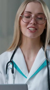 Mutlu gülümseyen doktor beyaz kadın hemşire üniformalı bayana bakıyor hasta laptopuna danışarak klinik hastane web sağlığı danışmanlığında iletişim kuruyor.