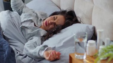 Kafkasyalı bir kadın kötü bir şekilde öksürük baş ağrısı çekiyor. Yatakta yatan baş ağrısı çekiyor. Solunum yetmezliği çekiyor.