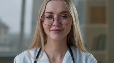 Kafkasyalı gülümseyen mutlu doktor kadın jest yapıyor kanser tedavisi için tedavi görüyor kadın kameraya bakan dişlek gülümsemeye bakıyor sağlık ilacı öneriyor gibi.