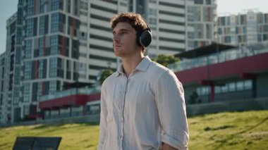 Kameraya bakan Avrupalı beyaz bir adam müzik kulaklıkları dinliyor mp3 erkek iş adamı şehir dışında sound street sound kablosuz öğrenci rahatlama aygıtı