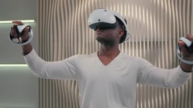 Yoğunlaşmış Afrikalı Amerikalı adam VR sanal gerçeklik kullanarak gelecekçilik alanında araştırma yapıyor erkek adam rahatlama üzerine çalışıyor modern yenilikçi cihaz meta-fütürist hobisiyle oynuyor