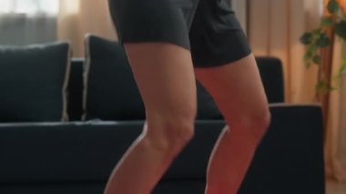 Aktif İspanyol kadın, evinde kardiyo sporu yapıyor. Zayıf, fit, spor yapan, spor yapan bir kız. Zıplayarak sağlıklı yaşam tarzını ısıtıyor.