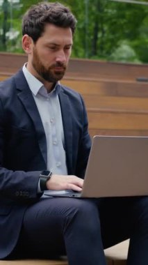 Beyaz iş adamı, açık havada dizüstü bilgisayarda çalışıyor. Fotoğrafçı, girişimci, iş adamı, mimar, işveren, sokak çalışması yapıyor. Bilgisayarda internet üzerinden bağlantı araştırması yapıyor.