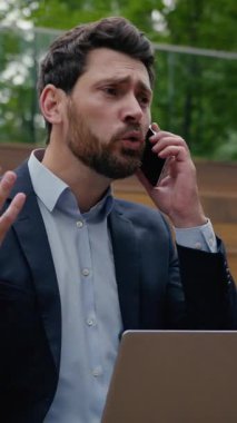 Öfkeli Kafkasyalı iş adamı Laptop Şehri 'nde çalışıyor. Cep telefonu sesinden bağır. Sinirli adam kavgası.