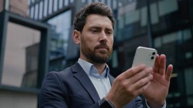 Kafkas erkek işadamı akıllı telefon kullanarak dışarıda mesaj yazıyor. Çevrimiçi şehir çocuğu işvereni, internet bağlantısı, cep telefonu bağımlısı cep telefonu ekran uygulaması alışverişi.