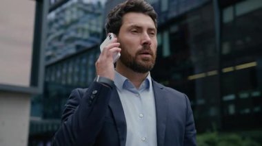 Beyaz erkek işadamı, şehir merkezinin dışında, resmi takım elbiseli, iş adamı, girişimci, emlakçı, işveren, büro telefonuna cevap veren, cep telefonu görüşmeleri yapan bir adam.