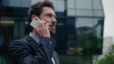 Ciddi Kafkasyalı iş adamı şehir dışında cep telefonundan konuşuyor. Yatırımcı, patron, yönetici, işveren, işveren, akıllı telefon. Müşteri danışmanı cep telefonu görüşmeleri yapıyor.