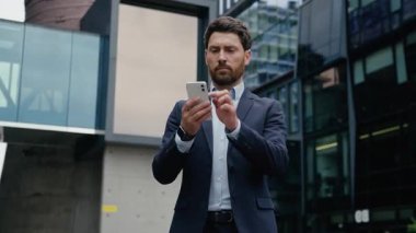 Kafkasyalı yetişkin iş adamı cep telefonu şehrine göz atıyor erkek işveren veri bağlantıları iş adamı yatırımcı adam akıllı telefon ekranı online uygulama cihazı bağımlısı açık hava