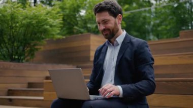 Mutlu Kafkasyalı işadamı şehir dışında çalışan iyi haberleri kutluyor neşeli erkek iş adamı işvereni internette e-posta bilgisayarı tarıyor ve zafer mesajı almayı teklif ediyor.