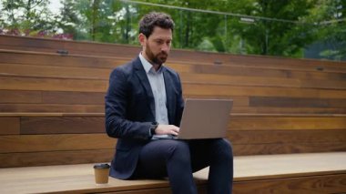 Beyaz iş adamı, açık havada dizüstü bilgisayarda çalışıyor. Fotoğrafçı, girişimci, iş adamı, mimar, işveren, sokak çalışması yapıyor. Bilgisayarda internet üzerinden bağlantı araştırması yapıyor.