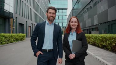 Kendine güvenen beyaz iş adamları şehirde kameraya bakan erkek kadın işadamları mutlu işadamları gülümseyen iş adamları şirket yöneticileri açık havada poz veren iş arkadaşları