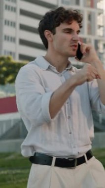 Saldırgan Kafkasyalı iş adamı şehir merkezindeki iş adamlarıyla cep telefonunu tartışıyor. Görüşme anlaşmazlığı tartışılıyor.