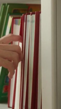 Erkek öğrencinin seçtiği el kitabı kütüphanedeki raftan alınıyor tanınmayan adam edebiyat akademik araştırma bilgisi araştırma eğitimi alıyor okulda öğrenim görüyor