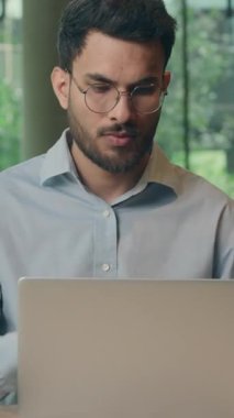 Hintli iş adamı bilgisayarla kafa yormayı düşünürken Kafe Arap iş adamı erkek yönetici girişimci kafeteryada dizüstü bilgisayar ağı ile kafa yoruyor ve içgörüyü buluyor.