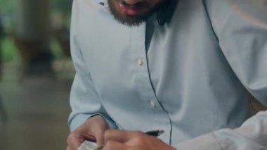 Stresli çoklu görev sahibi Hintli işadamı telefon yazma verilerine bakıyor çek makbuzuna bakıyor Arap erkek işadamı yöneticiliği cep telefonu faturaları hakkında konuşuyor.