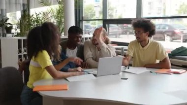 Çeşitlilik, diz üstü bilgisayarlı beş öğrenci üniversitedeki çok ırklı dostların masasında beşer başarılı bir online öğrenme çalışması yaparak başarıyı kutlayan e-öğrenme sınavları geçti.