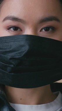Koreli kadın kapalı alanda siyah tıbbi maske takıyor. Hasta Japon kadın koronavirüs salgınını koruyor. Sağlık hizmetleri hastalığını önlüyor.