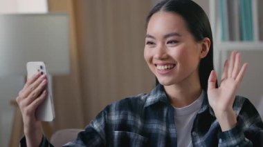 Gülümseyen Asyalı Koreli kadın blogcu konuşuyor. Video görüşmeleri yapıyor. Cep telefonu sallıyor, etnik kadın video blogcu.