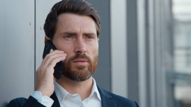 Ciddi bir beyaz iş adamı portresi. Cep telefonuyla konuşuyor. Müvekkilini arıyor. Yetişkin iş adamı, şirket CEO 'su.