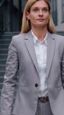 Başarılı orta yaşlı Kafkasyalı iş kadını ofis yakınında yürüyen yetişkin bir iş kadını. Şehir merkezinde kadın profesyonel yönetici olarak işe giriyor.