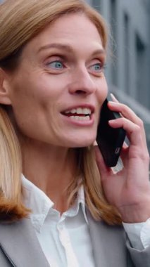 Mutlu Kafkasyalı yetişkin iş kadını cep telefonuyla konuşuyor başarıyı tartışıyor orta yaşlı iş kadını kadın uzman açık hava haberleri paylaşıyor akıllı telefon sohbetleri gülüyor