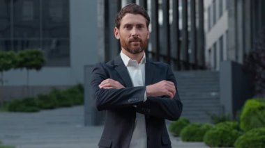 Resmi takım elbiseli, kendine güvenen Kafkasyalı, olgun iş adamı, şehrin yakınlarında gülümseyen, iş adamı pozu veren, mutlu bir iş adamı olarak, şehir merkezinde kameraya bakıp gülümseyen,