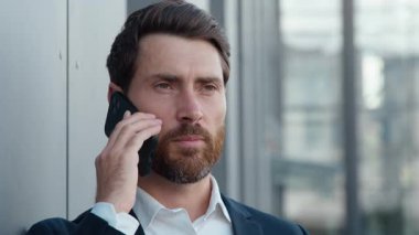 Ciddi bir beyaz iş adamı portresi. Cep telefonuyla konuşuyor. Müvekkilini arıyor. Yetişkin iş adamı, şirket CEO 'su.