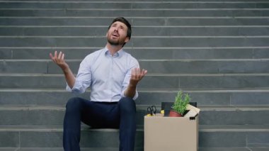 Stresli, beyaz, orta yaşlı iş adamı merdivenlerde oturuyor işten çıkarma kutusu kızgın, işveren erkek işvereni üzgün, işsiz, dışarıda mali kriz yaşıyor.