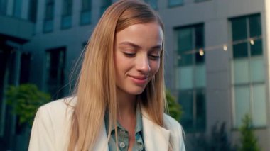 Dışarıda dizüstü bilgisayar yazan, gülümseyen beyaz kadın uzaktan kumandalı iş kadını mutlu kadın işkadını internet mağazasına göz gezdiren sosyal medya kontrol eden, bilgisayar işi yapan iş şehri.