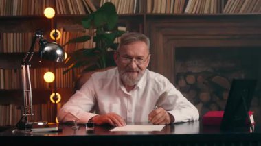 Portre mutlu yaşlı beyaz dede kameraya bakıyor neşeli iş adamı gülümse ev sahibi iş adamı yazar başarılı girişimci zengin kıdemli lider elinde dolmakalem işi tutan