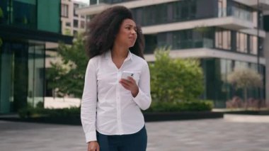 Afrikalı Amerikalı Asyalı Koreli iş kadınları cep telefonlarını kontrol ediyor şehir dışında endişeli iş arkadaşları patronla buluşmayı bekliyor.