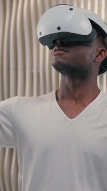 Yoğunlaşmış Afrikalı Amerikalı adam VR sanal gerçeklik kullanarak gelecekçilik alanında araştırma yapıyor erkek adam rahatlama üzerine çalışıyor modern yenilikçi cihaz meta-fütürist hobisiyle oynuyor