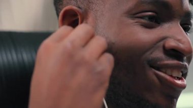 Afro-Amerikalı mutlu adam kulaklıklarını taktı ve favori müzikal şarkılarını dinledi. Fütürist uzay odasında müzik dinledi. Dinlenmiş kulaklık takan rahat bir erkek çocuğu dinledi.