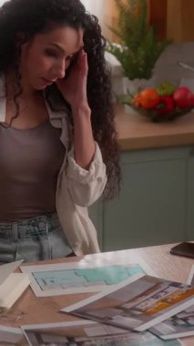 Yorgun Latin kadın tasarımcı ev projesi onarımı strese girdi İspanyol kadın fotoğraf odası şablonları seçiyor ev mutfağı baş ağrısı apartman dairesinde çalışan kız.