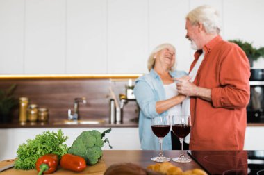 Mutfakta arka planda dans eden mutlu yaşlı çift.