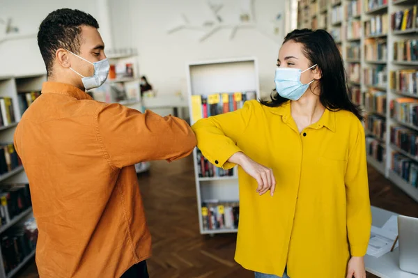 Estudante Feliz Amigos Vestindo Máscaras Protetoras Saudação Batendo Cotovelos Biblioteca — Fotografia de Stock