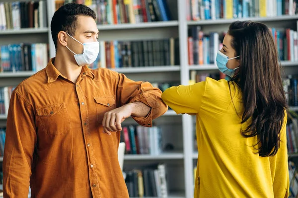 Estudante Feliz Amigos Vestindo Máscaras Protetoras Saudação Batendo Cotovelos Biblioteca — Fotografia de Stock