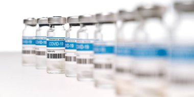 Beyaz zemin üzerinde COVID-19 Corona virüsü aşısı olan birçok ampulün panoramik fotoğrafı. Coronavirus aşısı imalatı, dünya çapında aşı ve sağlık konsepti