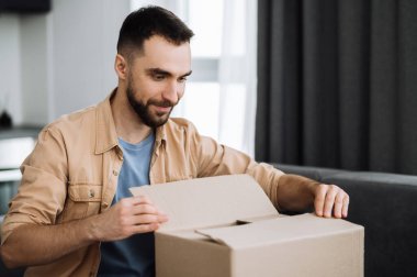 Eve teslim. Yakışıklı beyaz adam kanepeye oturur, karton kutuları açar, gülümser. Tatmin olmuş adam uzun zamandır beklenen bir paket aldı, İnternet mağazalarından alışveriş yapıyordu, online alışveriş konsepti.