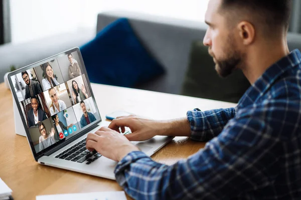 Online video meeting. Successful young adult businessman communicate with business colleagues by video call using laptop, discussing about financial future and strategy