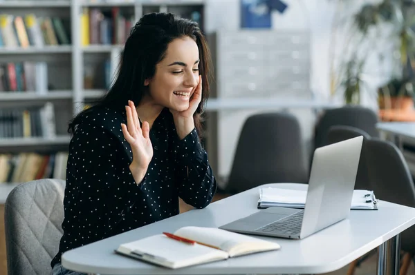 Radostná Mladá Žena Sedí Pracovního Stolu Mává Rukou Zdraví Kolegy — Stock fotografie