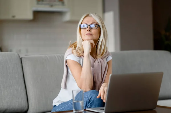 Érett Nyugodt Fehér Szemüveggel Otthon Kanapén Nappaliban Laptopot Használ Miközben — Stock Fotó