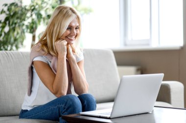 Beyaz kadın olgun son sınıf gülümsemesi yetişkin kadın dizüstü bilgisayar.