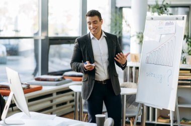 Arkadaş canlısı başarılı erkek menajer sunumu yapıyor, video konferansına rapor verin. İş arkadaşlarıyla çevrimiçi brifingde kendinden emin bir iş adamı, projeyi tartışıyor, uzaktan ofis işi kavramını tartışıyor.