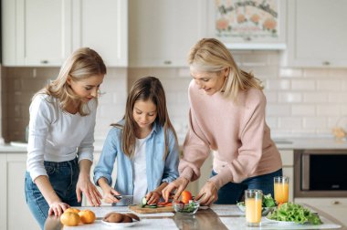 Üç nesildir kadınlar mutfakta birlikte vakit geçiriyorlar. Küçük kıza salata kesmeyi, gülümsemeyi ve birlikte olmaktan mutlu olmayı öğretiyorlar.