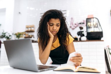 Hüsrana uğramış genç Afrikalı Amerikalı kadın küçük işletme sahibi, barista ya da garson, aylık küçük işletme hesapları, karantina ve iflastan kaynaklanan finansal kayıplar,