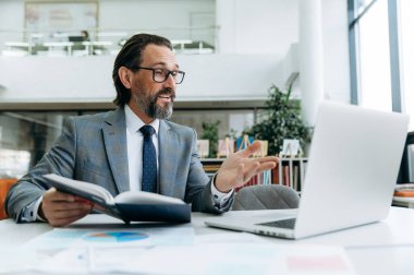 İş arkadaşlarıyla online brifing veren nüfuzlu olgun bir adam şirket için yeni iş planını açıklıyor. Güvenilir erkek patron çalışanlarla konuşuyor.