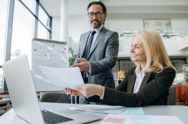 Başarılı üst düzey çalışanlar yeni projeler geliştiriyor, fikirleri tartışıyor. Güzel sarı saçlı kadın iş planı üzerinde çalışıyor. Çekici bir erkek arkadaşla.