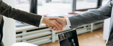 Başarılı iş ortaklarının görüşmelere başlarken el sıkışmalarının panoramik fotoğrafı. Konferansta iş arkadaşları, anlaşmaya varmak için önemli bir şirket projesini onayladılar.