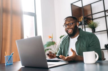 Evde uzaktan öğrenme, online çalışma. Afrikalı Amerikalı öğrenci ya da serbest çalışan öğrenme ya da çalışma için bilgisayar kullanıyor, video konferansı yapıyor.